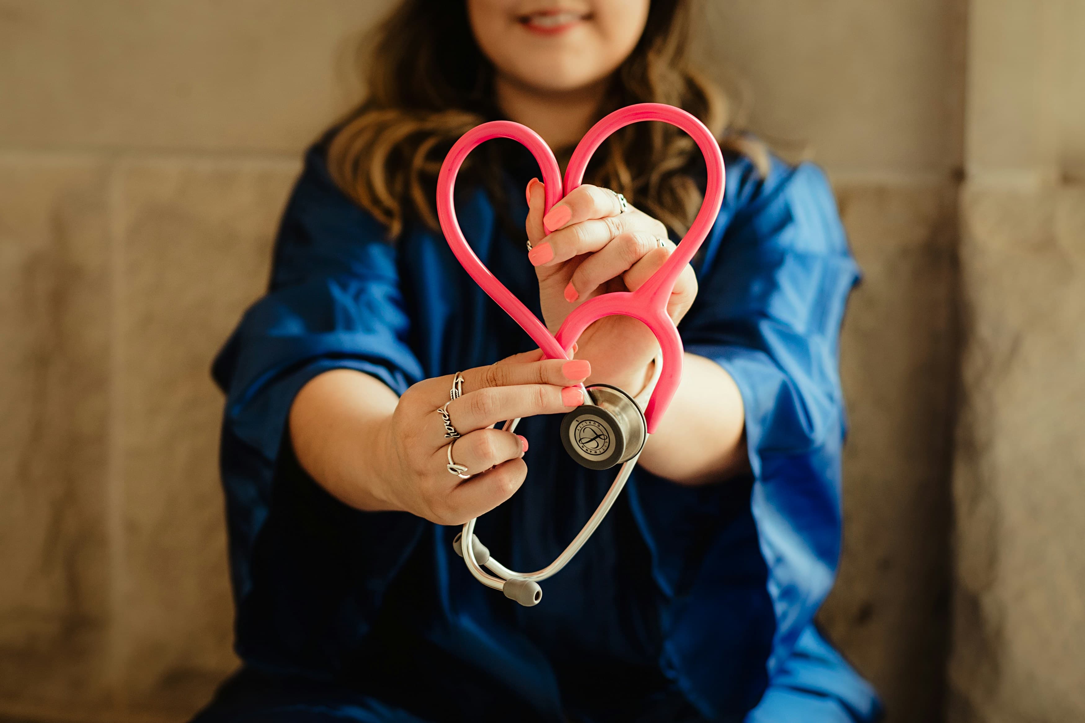 Healthcare worker holding a heart-shaped stethoscope
